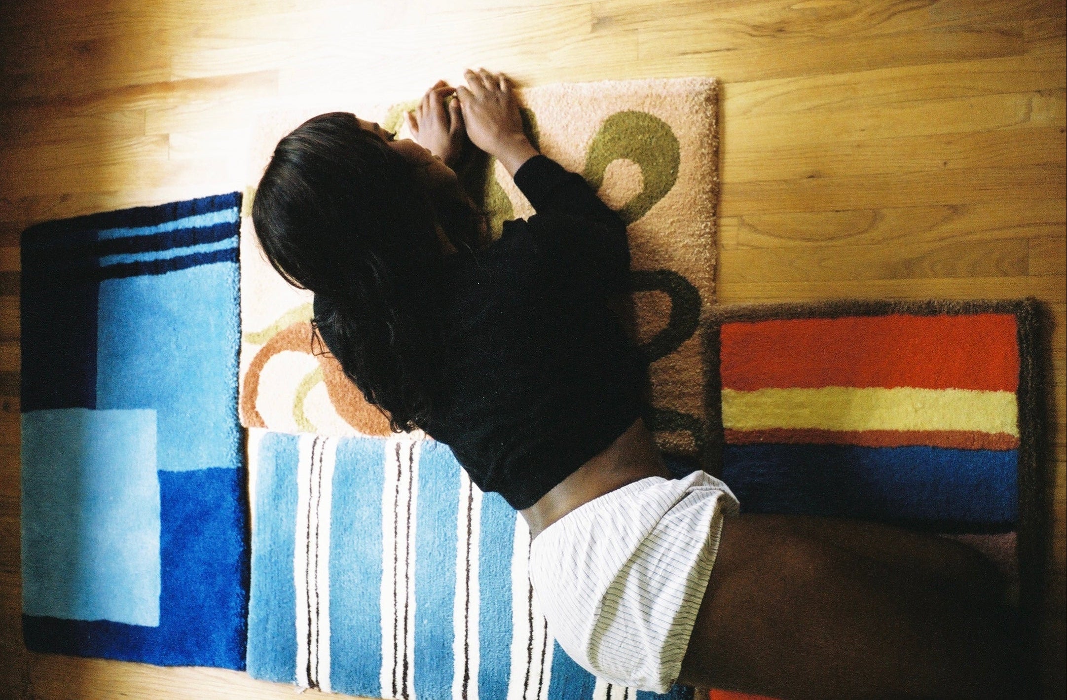 Person lying on a colorful rug with abstract patterns