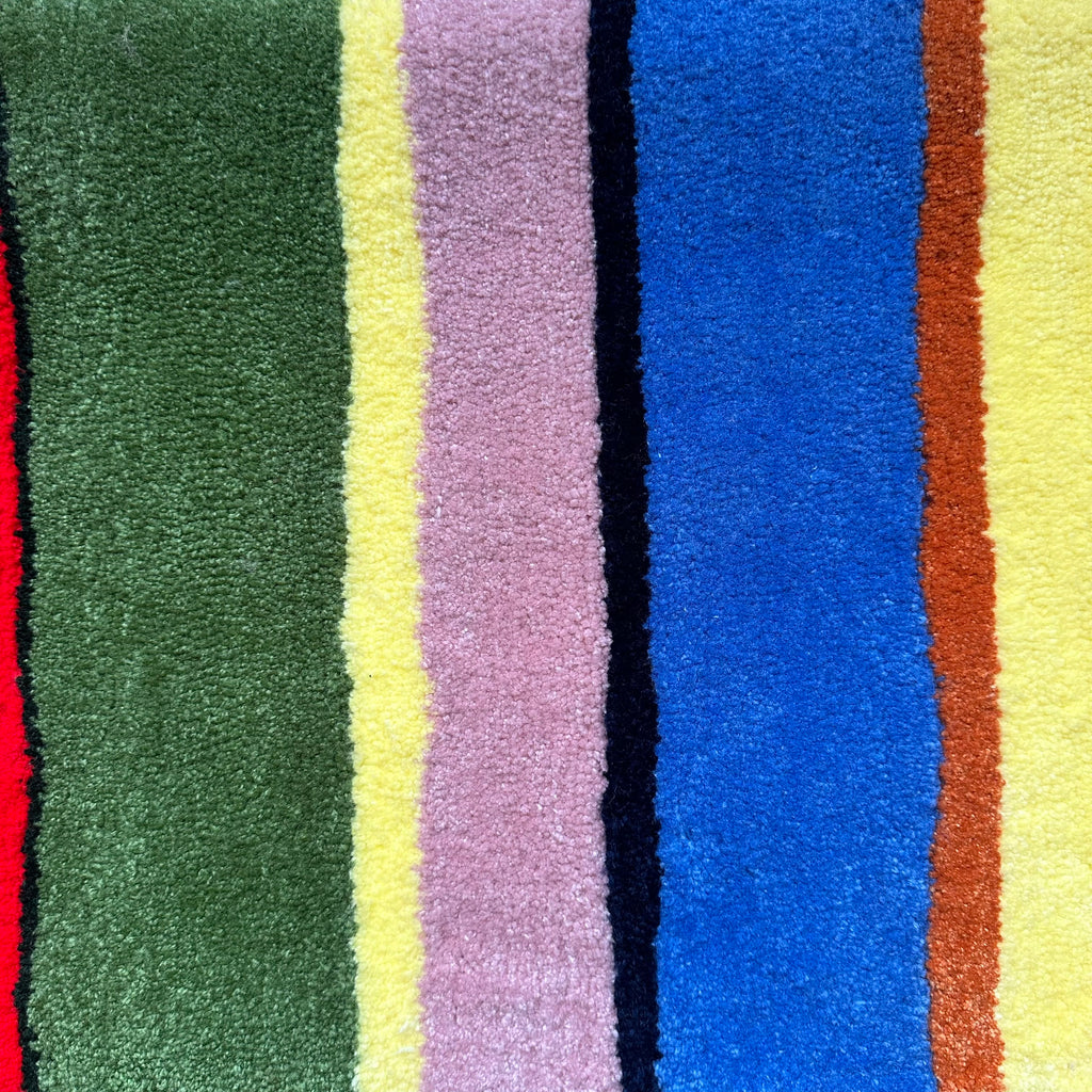 Multicolored striped fabric swatch with various colors including green, yellow, purple, blue, and brown.